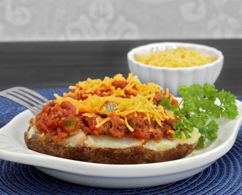baked potato topped with chili and cheese